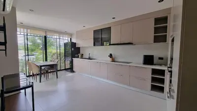 a kitchen with white cabinets and a table in it at Desiner Villa in Laguna Village, Bang Tao Beach, Phuket in Layan Beach
