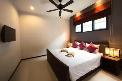 a bedroom with a large bed with red pillows at VILLA Miriama 2 Bedroom Near Naiharn Beach in Rawai Beach