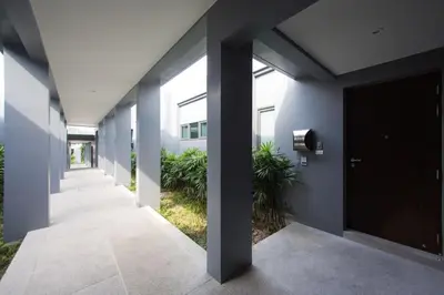 a hallway of a building with a black door and plants at VILLA Miriama 2 Bedroom Near Naiharn Beach in Rawai Beach