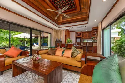 a living room with a couch and a table at Baan Bua Estate Villas by TropicLook in Nai Harn Beach