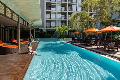 a woman and a dog in a pool at a hotel at Proud Phuket, Naiyang Beach in Nai Yang Beach