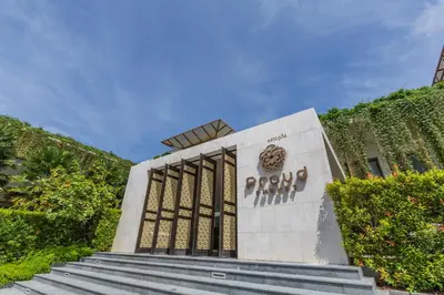 a monument in front of a building with stairs at Proud Phuket, Naiyang Beach in Nai Yang Beach