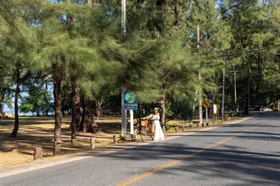 a woman standing on the side of a road at Proud Phuket, Naiyang Beach in Nai Yang Beach