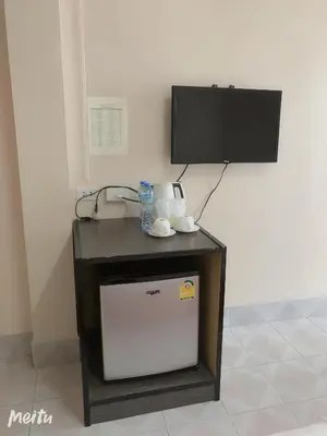 a table with a television and a white refrigerator at Baan Boa Guest House in Patong Beach