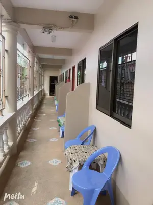 a hallway with blue chairs and windows at Baan Boa Guest House in Patong Beach
