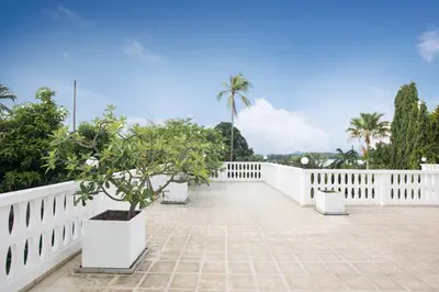 a white fence and trees on a patio at Grand 5BR Pool Villa Sea la Vie in Rawai Beach