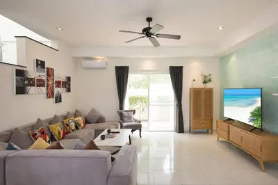 a living room with a couch and a flat screen tv at Grand 5BR Pool Villa Sea la Vie in Rawai Beach