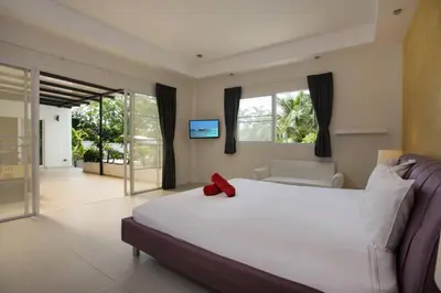 a bedroom with a white bed with a red bow on it at Grand 5BR Pool Villa Sea la Vie in Rawai Beach