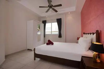 a bedroom with a white bed and a ceiling fan at Grand 5BR Pool Villa Sea la Vie in Rawai Beach