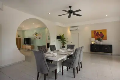 a dining room with a table with chairs and a ceiling fan at Grand 5BR Pool Villa Sea la Vie in Rawai Beach