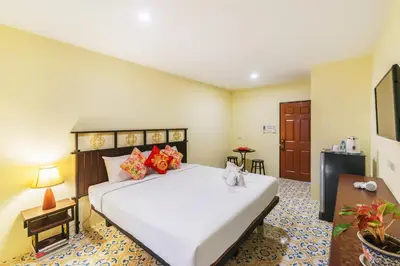 a bedroom with a large white bed in a room at Le Hua Hotel in Phuket Town