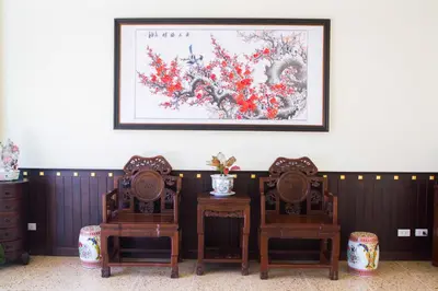 a table with two chairs and a picture on the wall at Le Hua Hotel in Phuket Town