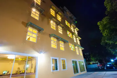 a building with lit up windows at night at Le Hua Hotel in Phuket Town