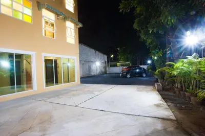 a parking lot in front of a building at night at Le Hua Hotel in Phuket Town