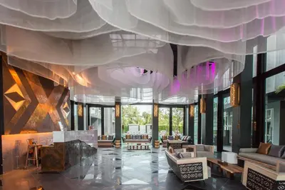 a lobby with a large room with tables and chairs at Maya Phuket Airport Hotel-Naiyang Beach in Nai Yang Beach
