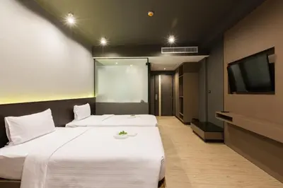 a hotel room with two beds and a flat screen tv at Maya Phuket Airport Hotel-Naiyang Beach in Nai Yang Beach