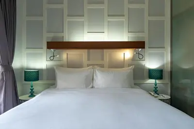 a bedroom with a large white bed with two lamps at TheLifeCo Phuket - Holistic Wellbeing Center in Nai Thon Beach