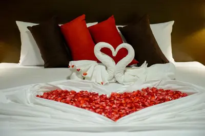 a heart made out of red peppers on a bed at Z-Talay House in Klong Muang Beach