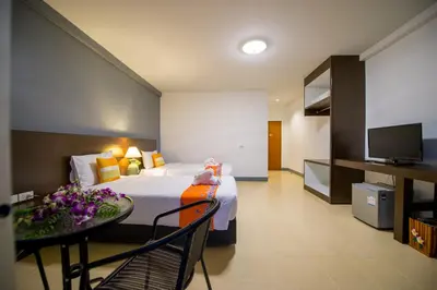 a hotel room with a bed and a table and a tv at Z-Talay House in Klong Muang Beach