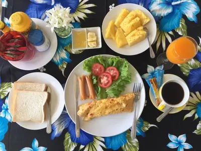 a table with plates of breakfast foods and coffee at Z-Talay House in Klong Muang Beach