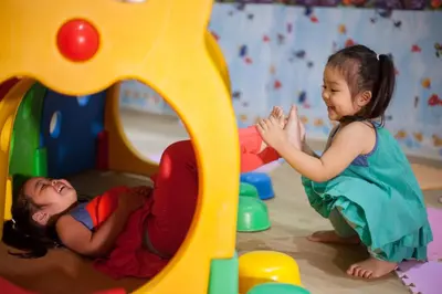 two little girls playing in a play set at Norn Talay Surin Beach Phuket in Surin Beach