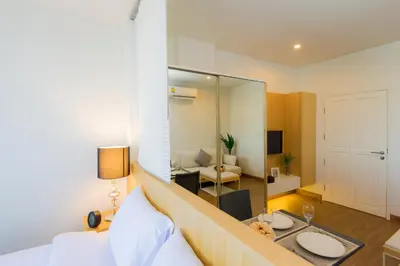 a hotel room with a bed and a living room at Hill Myna Condotel Official Account in Bang Tao Beach