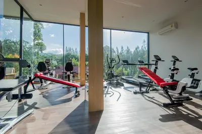 a gym with a bunch of exercise equipment in a room at Hill Myna Condotel Official Account in Bang Tao Beach