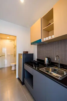 a kitchen with a sink and a refrigerator at Hill Myna Condotel Official Account in Bang Tao Beach