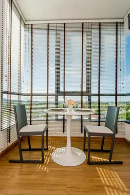 a table and two chairs in front of a large window at Hill Myna Condotel Official Account in Bang Tao Beach