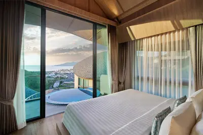 a bedroom with a bed and a large glass window at Patong Bay Hill in Patong Beach