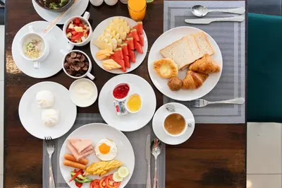 a table with plates of breakfast food on it at The Gig Hotel in Patong Beach