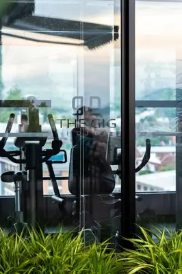 a person taking a picture through a glass window at The Gig Hotel in Patong Beach