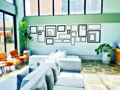 a waiting room with couches and a wall with pictures at The Sixteenth Naiyang Beach Hotel- Free Schedule Airport Shuttle in Nai Yang Beach