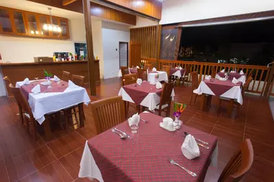 a restaurant with tables and chairs with red and white tablecloths at Chalong Princess Pool Villa Resort SHA EXTRA PLUS in Chalong
