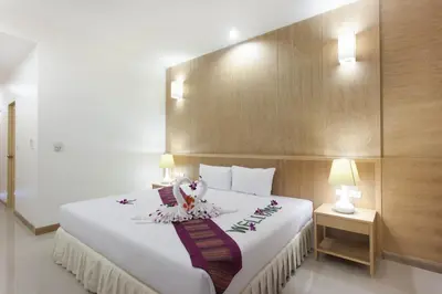 a bedroom with a large white bed with flowers on it at Chalong Princess Pool Villa Resort SHA EXTRA PLUS in Chalong