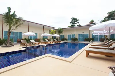 a hotel with a swimming pool with chairs and umbrellas at Chalong Princess Pool Villa Resort SHA EXTRA PLUS in Chalong