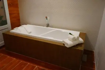 a bath tub with two rolled towels in a bathroom at Ruen Tai Boutique in Nai Yang Beach