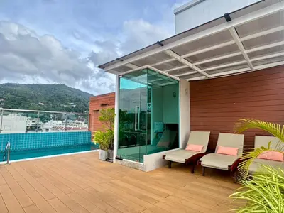a patio with two chairs and a glass wall at Centro One Bangla in Patong Beach