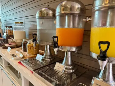 a kitchen with two large containers of orange juice at Centro One Bangla in Patong Beach