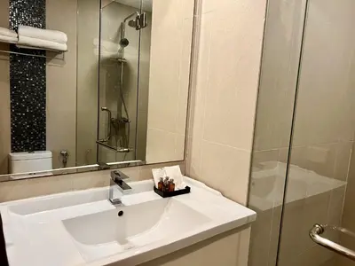 a bathroom with a white sink and a shower at Centro One Bangla in Patong Beach