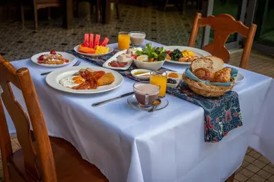 a white table with plates of food on it at Coriacea Beachfront Boutique Phuket Resort in Mai Khao Beach