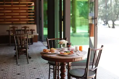 a table with a plate of food on it at Coriacea Beachfront Boutique Phuket Resort in Mai Khao Beach