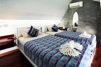 a hotel room with two beds and a mirror at Phuket Paradiso in Chalong