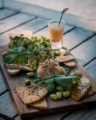 a plate of food with broccoli and bread and a drink at The Cove in Panwa Beach