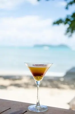 a drink in a martini glass sitting on a table at The Cove in Panwa Beach