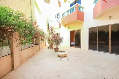 a courtyard of a building with potted plants at Ban Elephant Blanc Apartment in Kata Beach