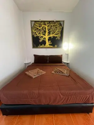 a large bed in a room with a picture on the wall at Ban Elephant Blanc Apartment in Kata Beach