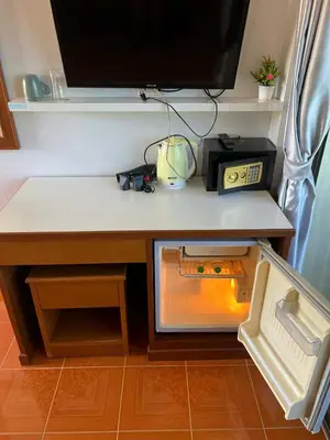 a desk with a microwave and a television on it at Ban Elephant Blanc Apartment in Kata Beach