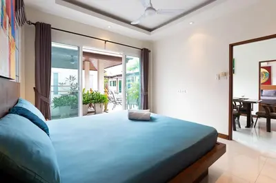 a bedroom with a large blue bed in a room at Residence Harmonie in Rawai Beach