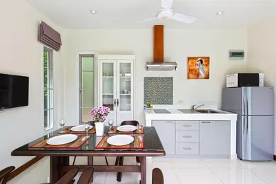 a kitchen with a table and a refrigerator at Residence Harmonie in Rawai Beach